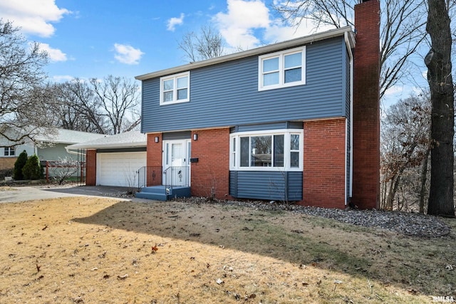 colonial-style house with concrete driveway, an attached garage, brick siding, and a chimney