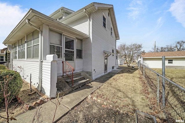 view of front facade featuring a sunroom and fence