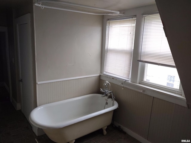 bathroom with a freestanding tub, plenty of natural light, wainscoting, and tile patterned flooring