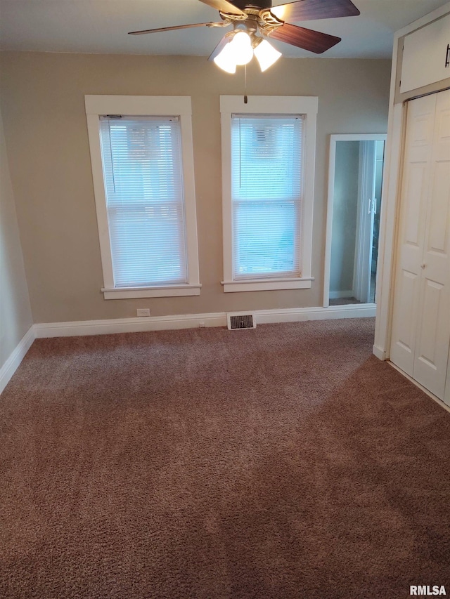 spare room with carpet flooring, baseboards, visible vents, and ceiling fan