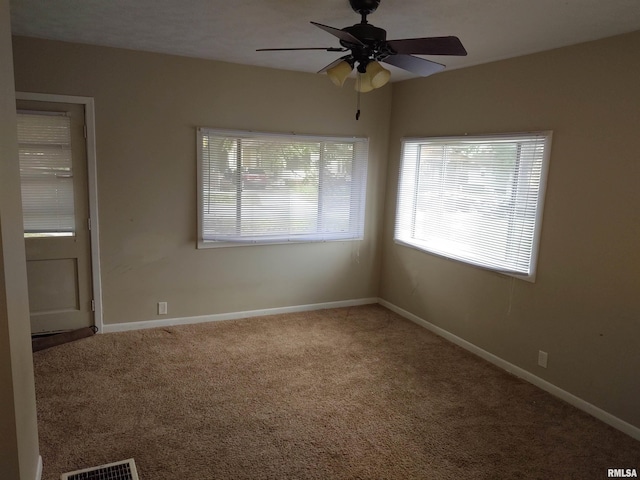 empty room featuring visible vents, baseboards, carpet, and a ceiling fan