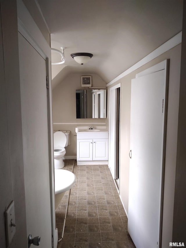 bathroom featuring vanity, lofted ceiling, and toilet