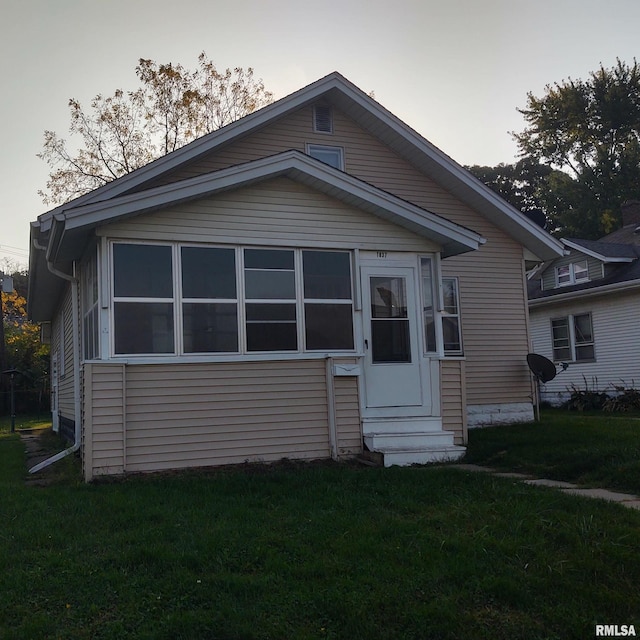 bungalow with entry steps and a front yard