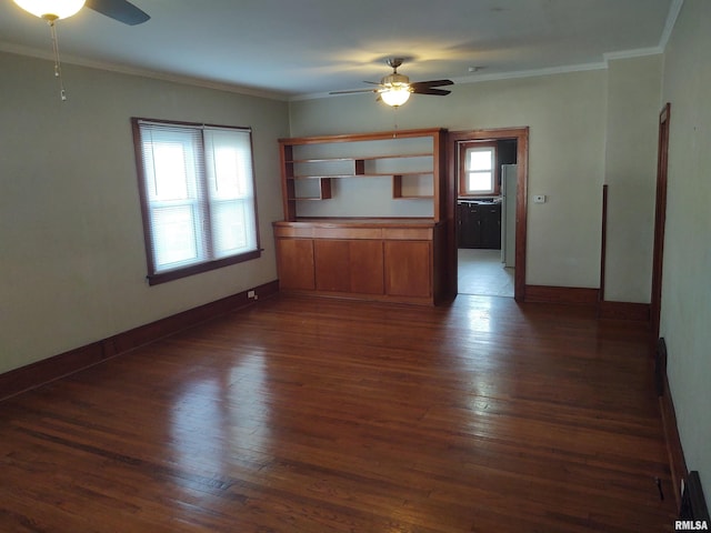 unfurnished living room featuring dark wood-type flooring, a wealth of natural light, and ornamental molding