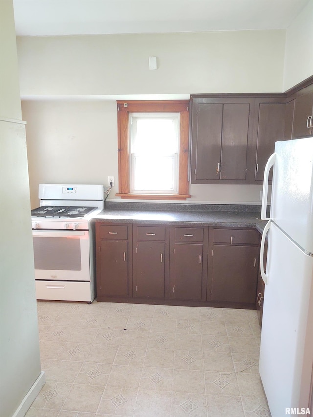 kitchen with white appliances, dark brown cabinets, and dark countertops