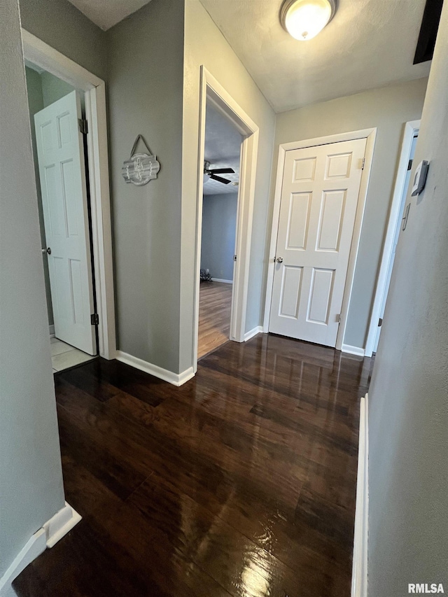 corridor featuring wood finished floors and baseboards