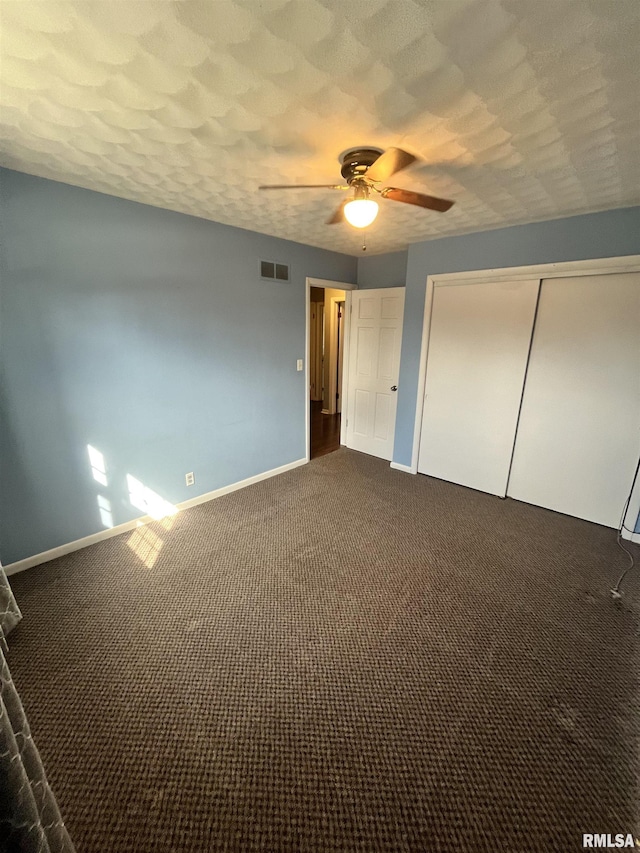 unfurnished bedroom featuring visible vents, a textured ceiling, a closet, carpet floors, and baseboards