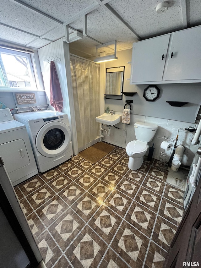 laundry room with laundry area, separate washer and dryer, and a sink