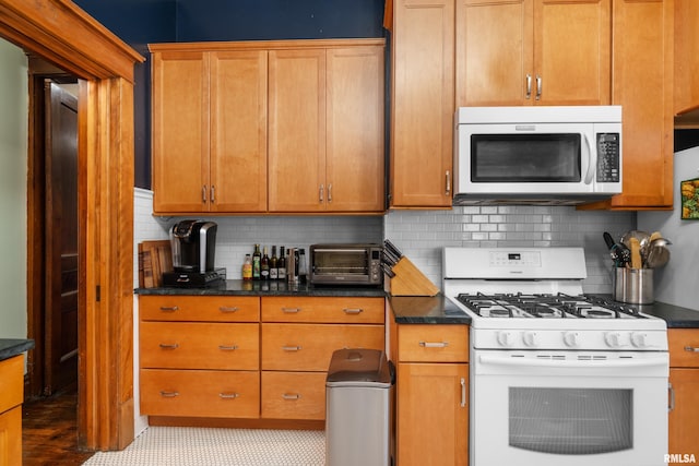 kitchen with a toaster, brown cabinets, white range with gas stovetop, and decorative backsplash