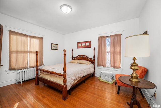 bedroom featuring radiator heating unit and light wood-type flooring