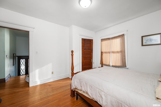 bedroom with a closet, baseboards, and wood finished floors