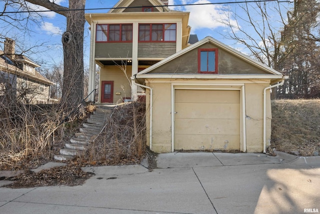 view of front of home featuring a garage, concrete driveway, and stucco siding