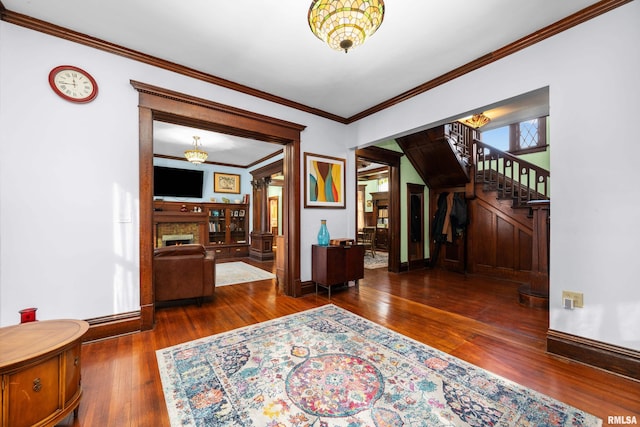 interior space featuring stairway, wood-type flooring, baseboards, and a warm lit fireplace