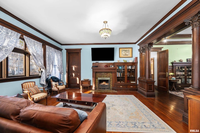 living area with decorative columns, a fireplace with flush hearth, dark wood-type flooring, and crown molding