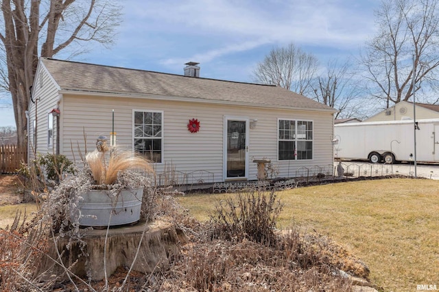 view of front of property featuring a front lawn, fence, and roof with shingles