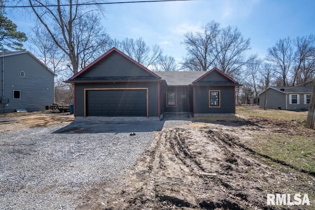 view of front of house with gravel driveway and an attached garage