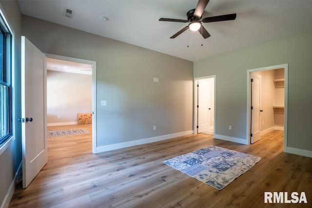 207 Rowatt St, Cambria, IL 62915 - unfurnished bedroom featuring a spacious closet, light wood-style floors, baseboards, and ceiling fan