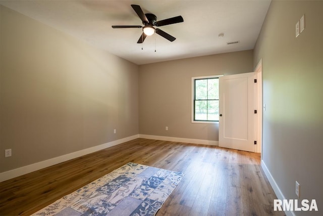 207 Rowatt St, Cambria, IL 62915 - spare room featuring wood finished floors, a ceiling fan, and baseboards