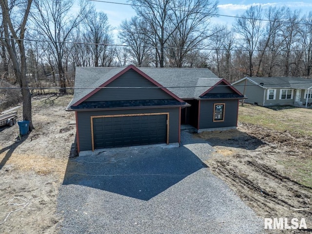 view of front of property with an attached garage, driveway, and roof with shingles