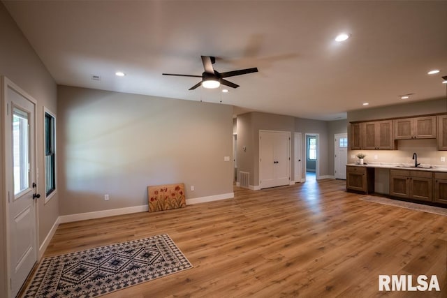 207 Rowatt St, Cambria, IL 62915 - unfurnished living room with a sink, baseboards, light wood-style flooring, a ceiling fan, and recessed lighting