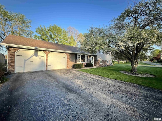 split level home with a front yard, an attached garage, brick siding, and driveway