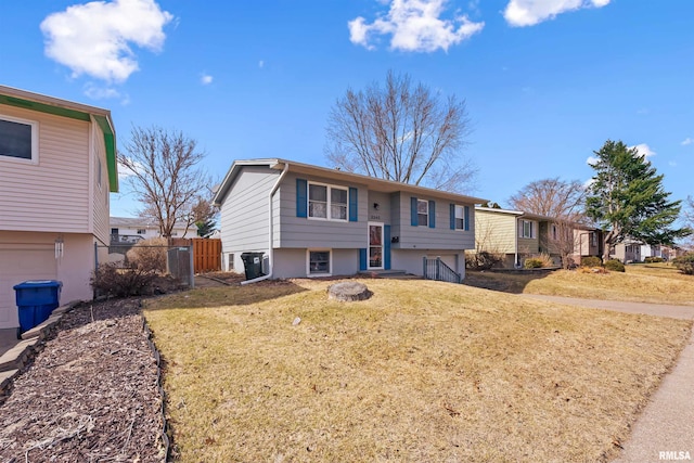 split foyer home with a front yard and fence