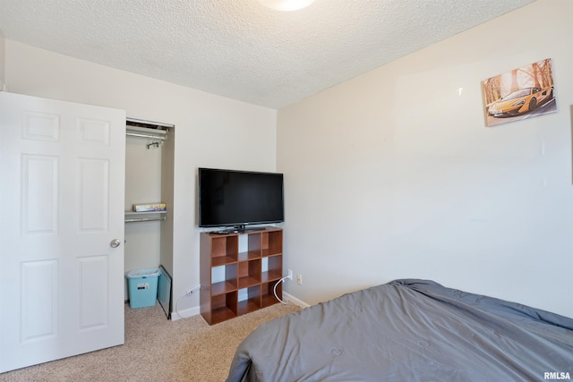 carpeted bedroom with baseboards and a textured ceiling