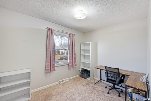 office area with visible vents, carpet flooring, a textured ceiling, and baseboards