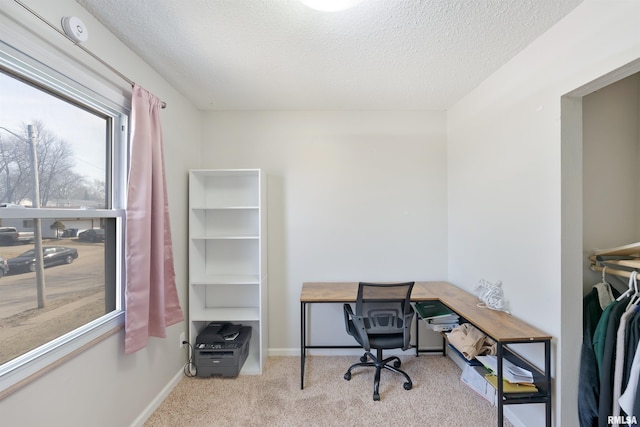 office with baseboards, a textured ceiling, and carpet