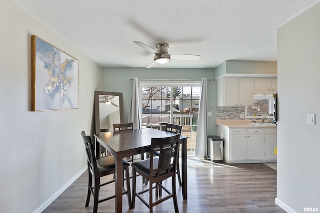 dining room featuring ceiling fan, a textured ceiling, baseboards, and wood finished floors