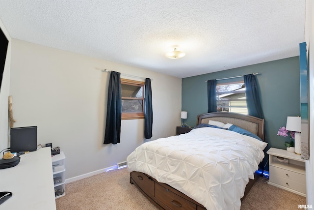 bedroom featuring carpet, baseboards, and a textured ceiling