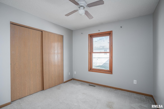 unfurnished bedroom featuring light carpet, visible vents, baseboards, and a closet