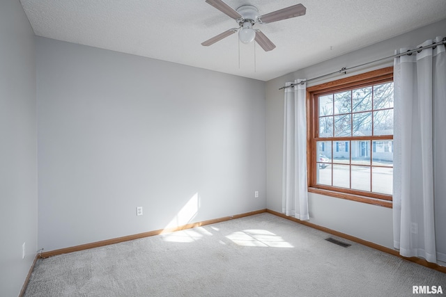 empty room featuring visible vents, ceiling fan, baseboards, carpet floors, and a textured ceiling