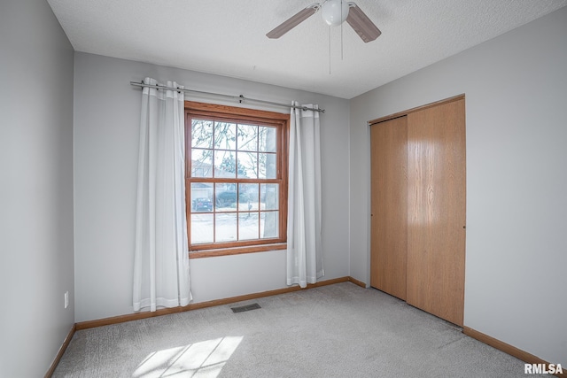 unfurnished bedroom featuring visible vents, baseboards, light colored carpet, and a closet