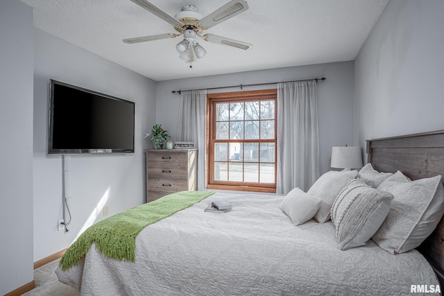 carpeted bedroom with ceiling fan, a textured ceiling, and baseboards