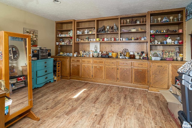 office with light wood-style flooring and a textured ceiling