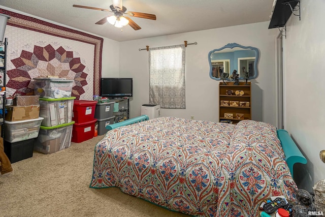 bedroom featuring a ceiling fan, carpet, and a textured ceiling