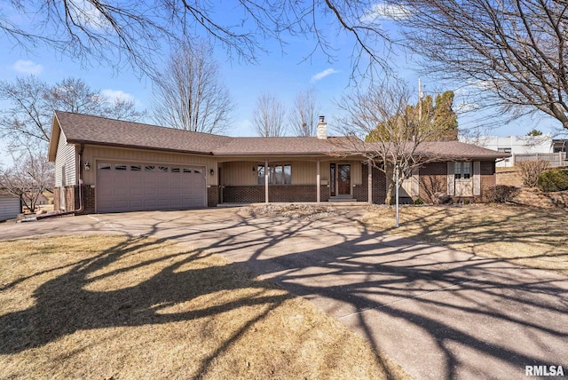 ranch-style house featuring brick siding, driveway, a chimney, and an attached garage