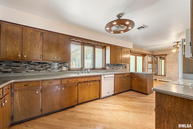 kitchen featuring tasteful backsplash, visible vents, light wood-style floors, and white dishwasher