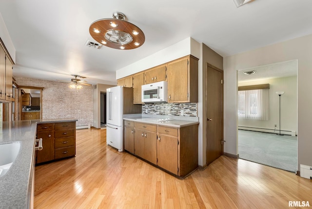 kitchen featuring visible vents, white appliances, light wood-style floors, light countertops, and baseboard heating