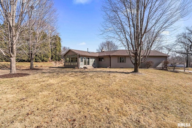 back of house with a lawn and a sunroom