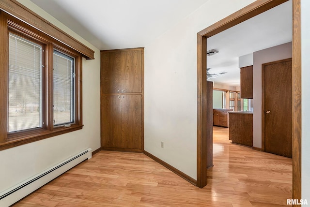 hall with a baseboard radiator, baseboards, visible vents, and light wood-style flooring