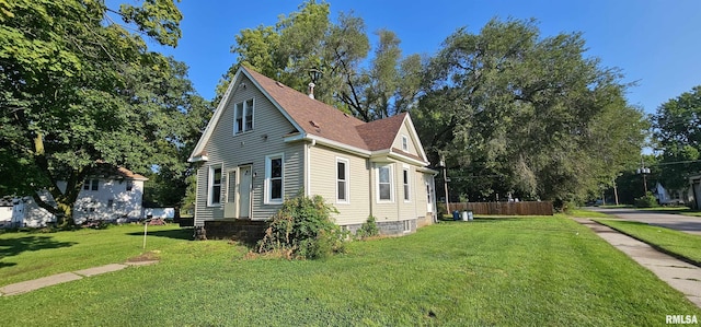 view of side of property with a lawn, fence, and roof with shingles