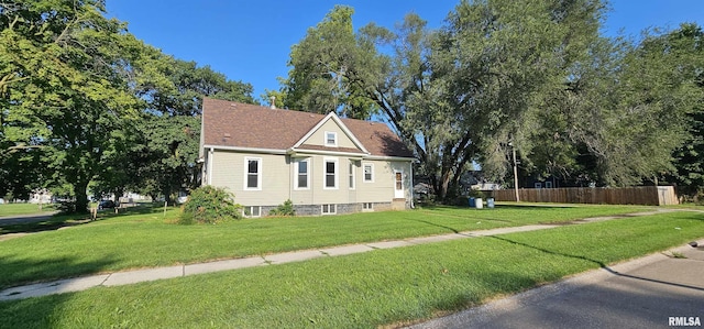 view of front of home with a front yard and fence