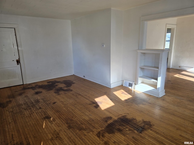 unfurnished room featuring hardwood / wood-style flooring and visible vents