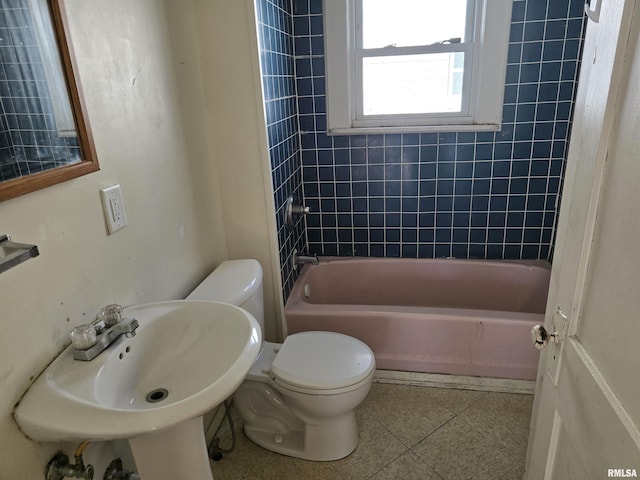 bathroom featuring tile patterned floors, toilet, shower / bathtub combination, and a sink