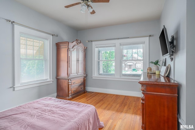 bedroom with baseboards, light wood-type flooring, and ceiling fan