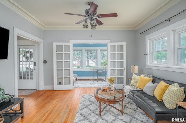 living area featuring wood finished floors, a wealth of natural light, and ornamental molding