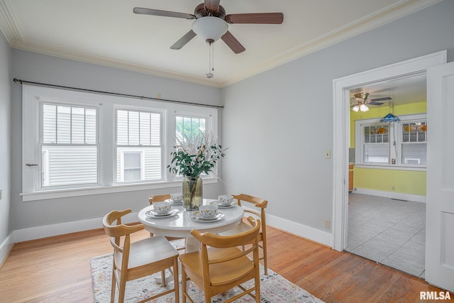 dining area with a ceiling fan, light wood-style floors, baseboards, and ornamental molding