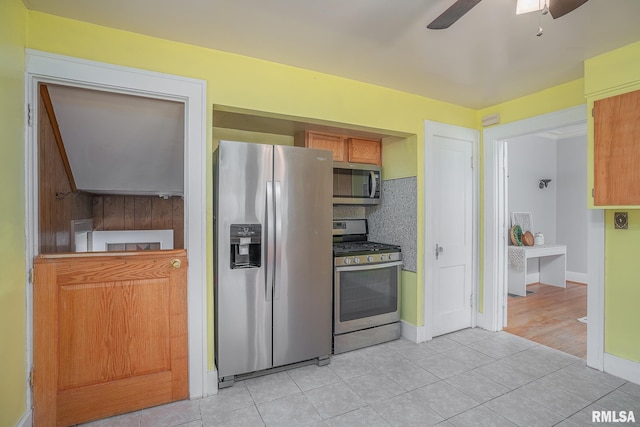 kitchen with light tile patterned floors, a ceiling fan, baseboards, decorative backsplash, and appliances with stainless steel finishes